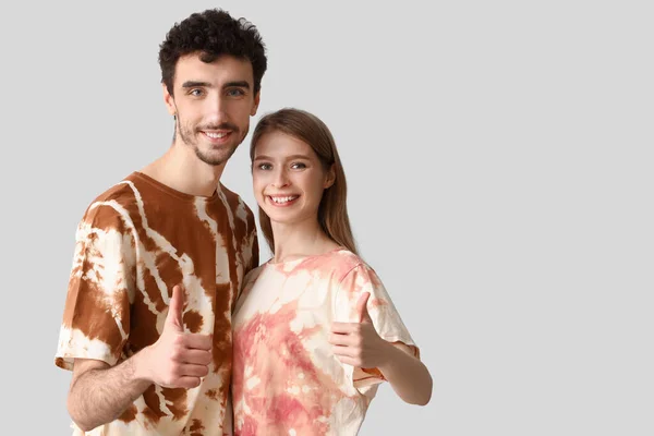 Jovem Casal Tie Dye Shirts Mostrando Polegar Fundo Claro — Fotografia de Stock