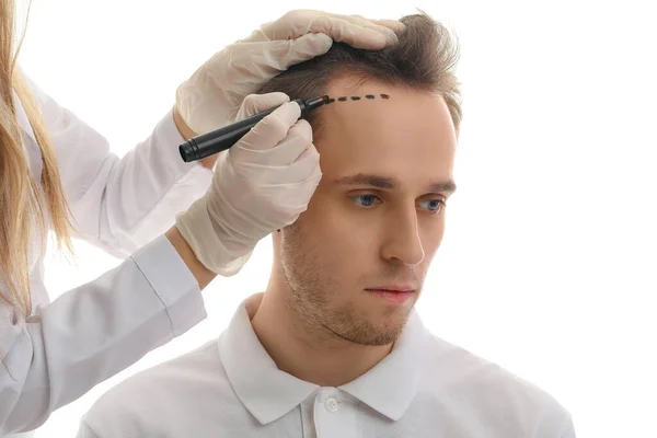 Doctor Marking Young Man Forehead Hair Loss Problem White Background — Stock Photo, Image