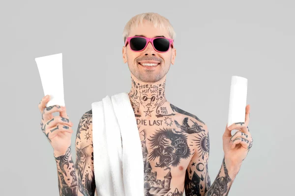 Homem Tatuado Com Cremes Protetores Solares Sobre Fundo Claro — Fotografia de Stock