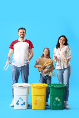 Aile çöpleri mavi arka planda geri dönüşüm kutularıyla sıralıyor