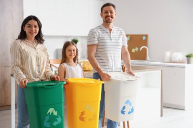 Mutfakta çöp bidonları olan bir aile.