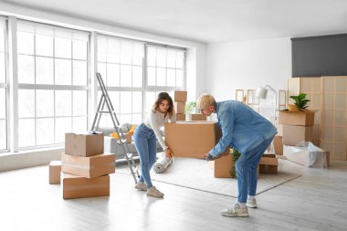 Taşındığı gün odada karton kutu taşıyan genç bir çift.