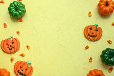 Sarı arka planda lezzetli Cadılar Bayramı şekerli mısır ve balkabaklı kompozisyon