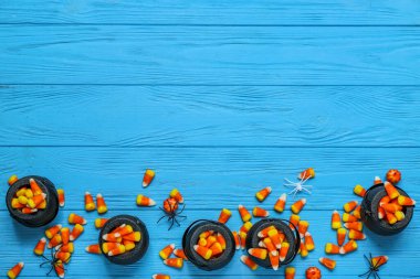 Lezzetli cadılar bayramı şekerleri ve renkli ahşap arka planda örümcekler