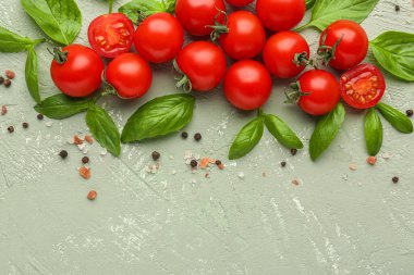 Renkli arkaplanda olgun kiraz domatesleri, fesleğen yaprakları ve biberli mısır kompozisyonu