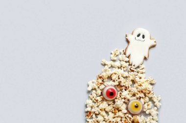 Hafif arka planda lezzetli patlamış mısır, kurabiye ve şekerler. Cadılar Bayramı