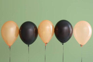 Yeşil arka planda farklı Cadılar Bayramı balonları
