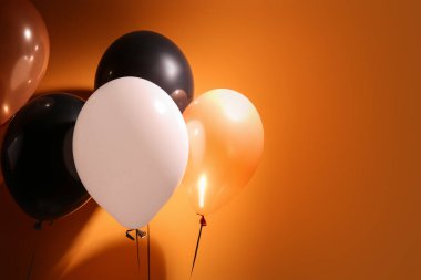 Turuncu arka planda farklı Cadılar Bayramı balonları, yakın plan
