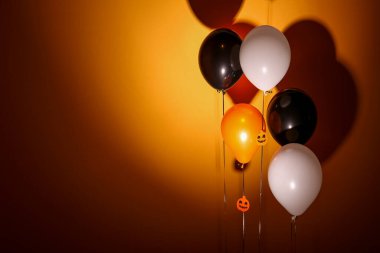 Koyu turuncu arka planda Cadılar Bayramı balonları
