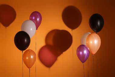 Koyu turuncu arka planda Cadılar Bayramı balonları