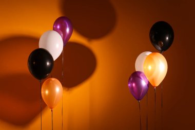 Koyu turuncu arka planda Cadılar Bayramı balonları