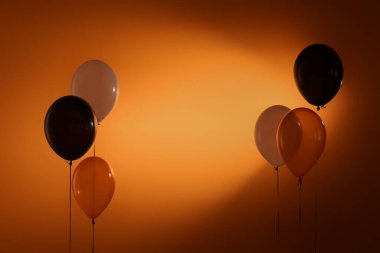 Koyu turuncu arka planda Cadılar Bayramı balonları