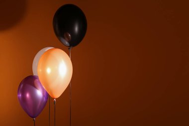Koyu turuncu arka planda Cadılar Bayramı balonları