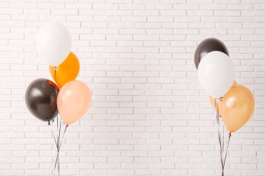 Aydınlık tuğla duvarın yanında farklı Cadılar Bayramı balonları