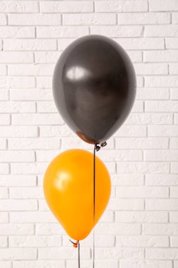 Aydınlık tuğla duvarın yanında farklı Cadılar Bayramı balonları