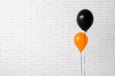 Aydınlık tuğla duvarın yanında farklı Cadılar Bayramı balonları