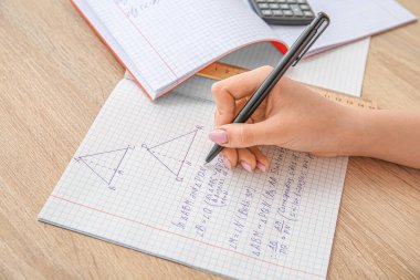 Tahta masaya matematik formülleri yazan bir kadın.
