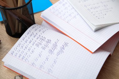 Tahta masanın üzerinde matematik formülleriyle metin kitaplarını aç, kapat