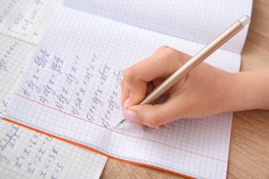Tahta masaya matematik formülleri yazan bir kadın.