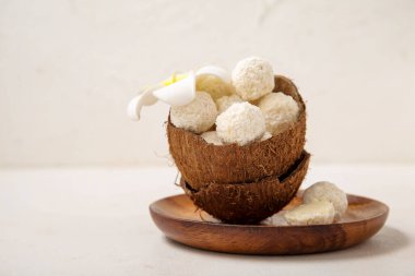 Beyaz çikolata şekerli hindistan cevizi kabuğu ve ışık masasında da plumeria çiçeği