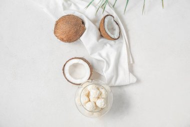 Beyaz çikolata şekerli cam kase ve ışık masasında hindistan cevizi