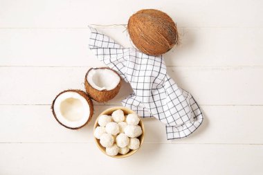 Beyaz çikolatalı kase ve açık ahşap masada hindistan cevizi.