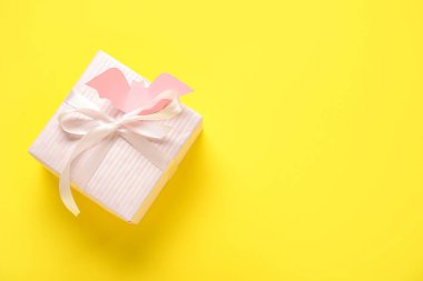 Sarı arka planda Cadılar Bayramı için kağıttan yapılmış güzel hediye kutusu ve yarasa.