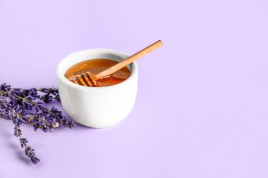 Bir kase tatlı lavanta balı, leylak arkaplanda çiçek