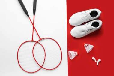 Bir çift spor ayakkabısı, badminton raketi, mekik horozu ve kulaklık.