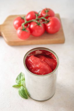 Açık arkaplanda domatesli teneke kutu