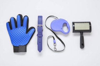 Hafif arka planda tasmalı bir takım hayvan bakım aksesuarları.