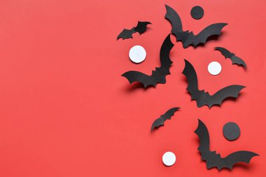 Kırmızı arka planda Cadılar Bayramı partisi için kağıt yarasalar