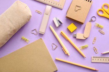 Mor arkaplan üzerine not defterleri ve okul kırtasiyesi
