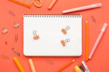 Kırmızı arkaplanda kırtasiye malzemesi olan kompozisyon