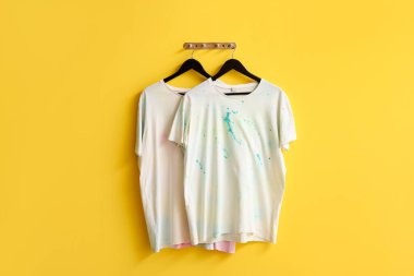 Sarı arkaplanda asılı şık beyaz tişörtler