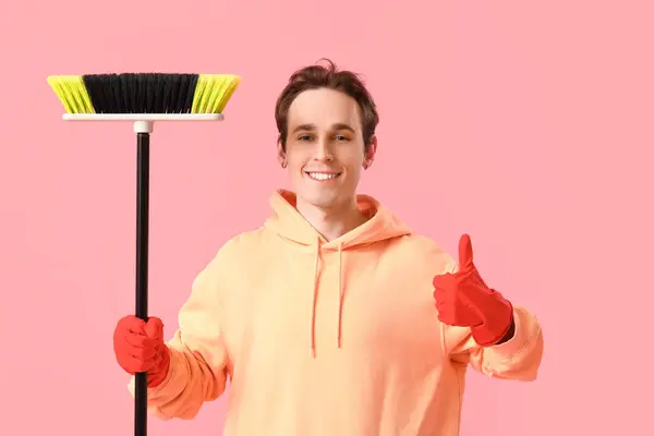 Young Man Broom Showing Thumb Pink Background — Stock Photo, Image
