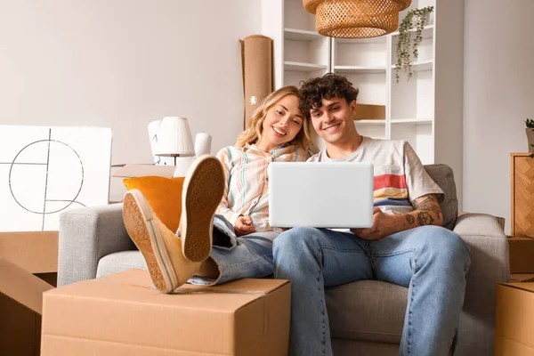 stock image Young couple using laptop in room on moving day