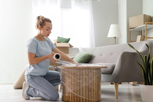 Young Woman Wrapping Coffee Table Stretch Film Home — Stock Photo, Image