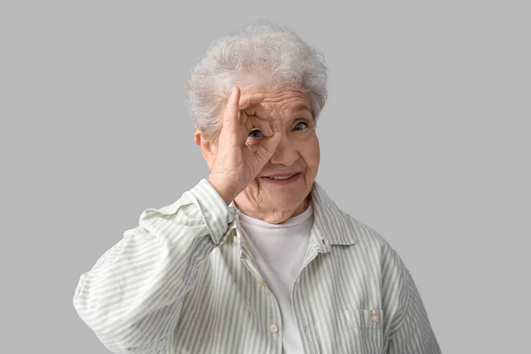 Senior Woman Showing Grey Background — Stock Photo, Image