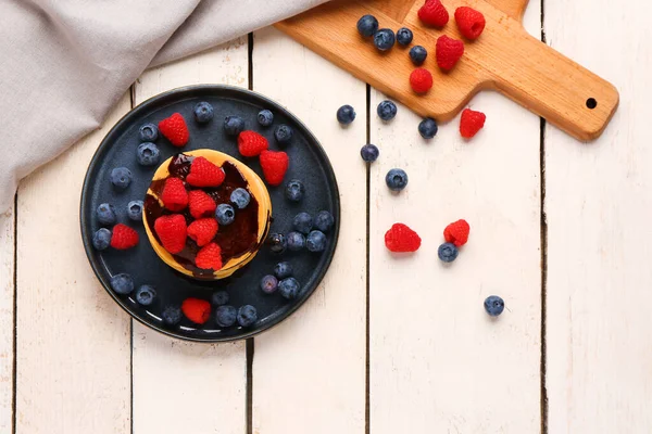 stock image Plate with sweet pancakes and berries on light wooden background