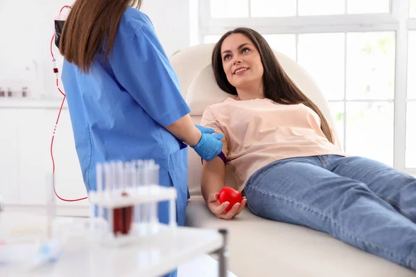 stock image Female doctor preparing young donor for blood transfusion in clinic