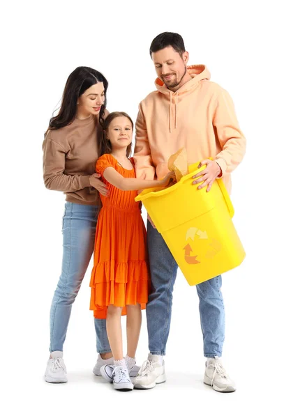 彼女の両親と小さな女の子は白い背景にリサイクルビンに紙のゴミを投げる — ストック写真