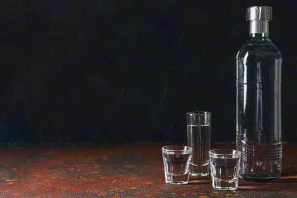 stock image Bottle and glasses of vodka on table