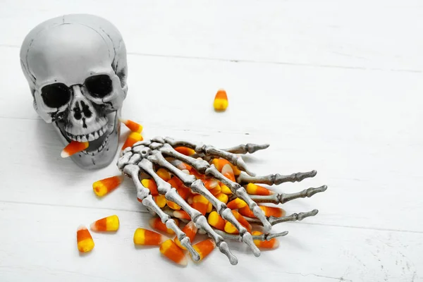 Tasty Halloween Candy Corns Skeleton Hands Skull Light Wooden Background — Stock Photo, Image