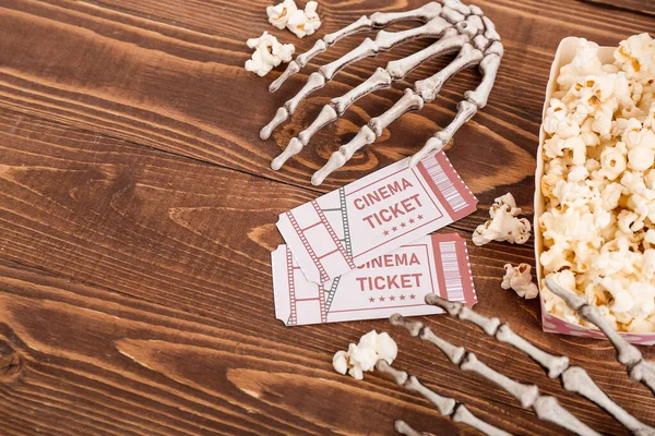 纸盒上有美味的爆米花 骷髅手和木制背景的电影票 万圣节庆祝活动 — 图库照片