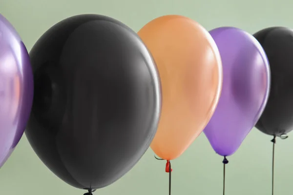 Different Halloween balloons on green background, closeup