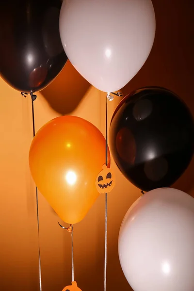 Halloween balloons on dark orange background