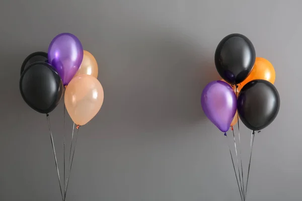 Different Halloween balloons on grey background