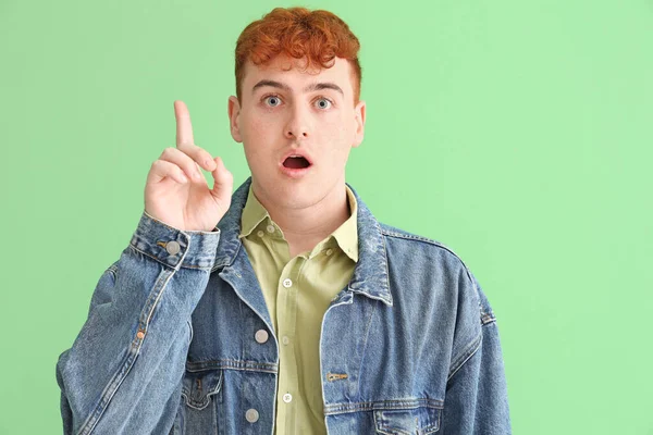 Genç Kızıl Adam Yeşil Arka Plandaki Bir Şeyi Işaret Ediyor — Stok fotoğraf