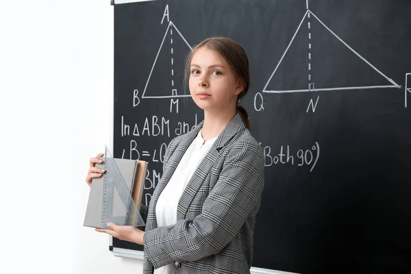 教室里 年轻的数学老师在黑板边看书 — 图库照片